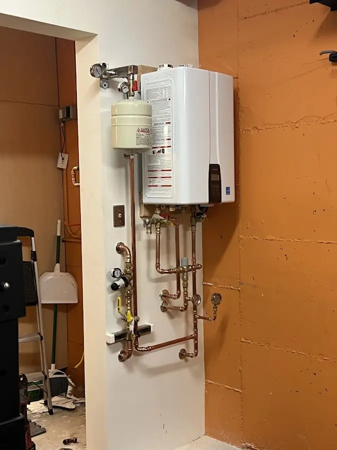 Plumbing technician inspecting water heater connections in Lawrenceburg